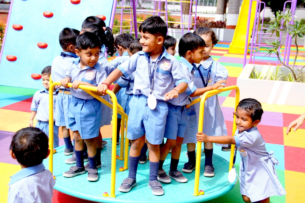 Tiny Tots of Nursery Playing on Carousal at School Playground
